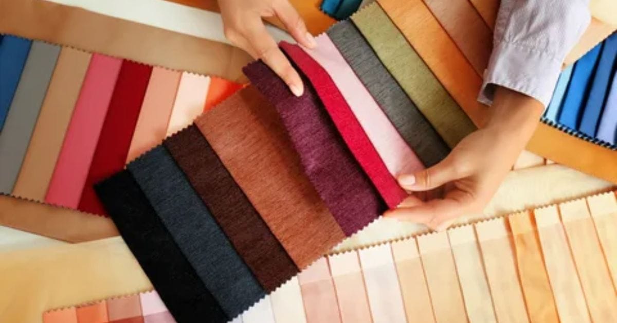 A person holds a sample of high-quality fabric, showcasing its texture and color in their hand.