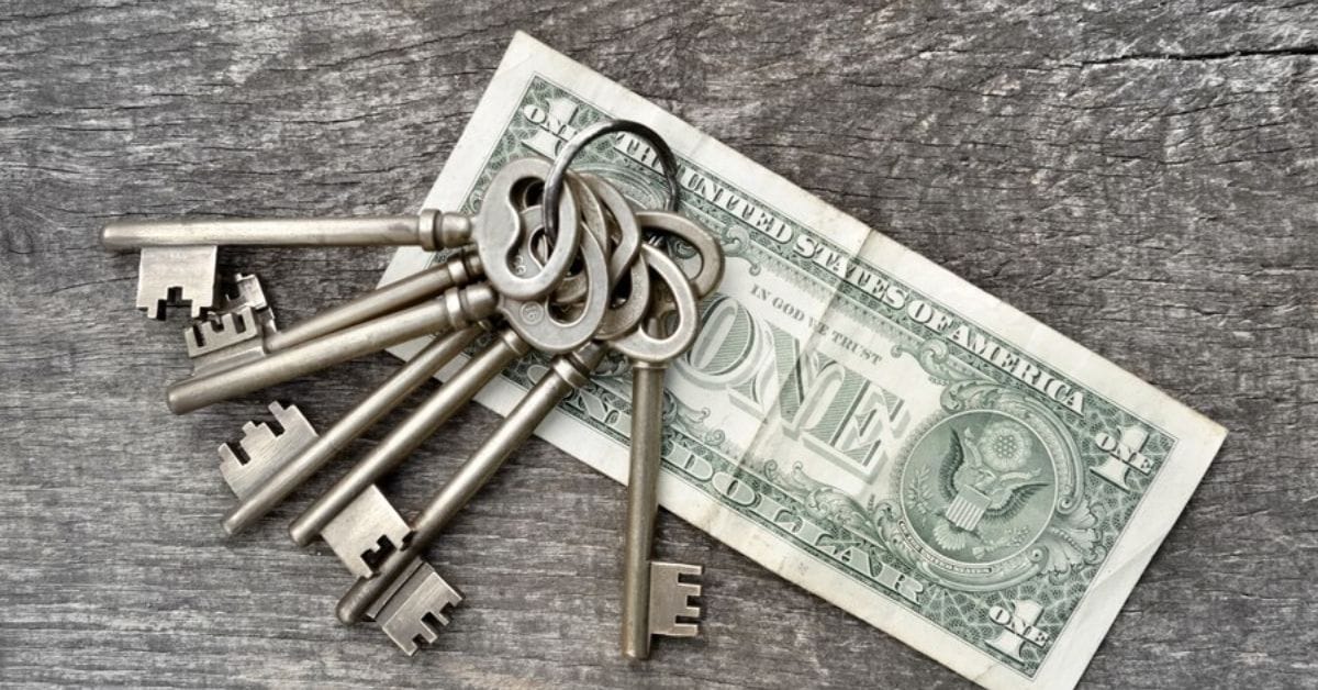 A pile of vintage keys alongside a crisp dollar bill, symbolizing the elegance of old money style