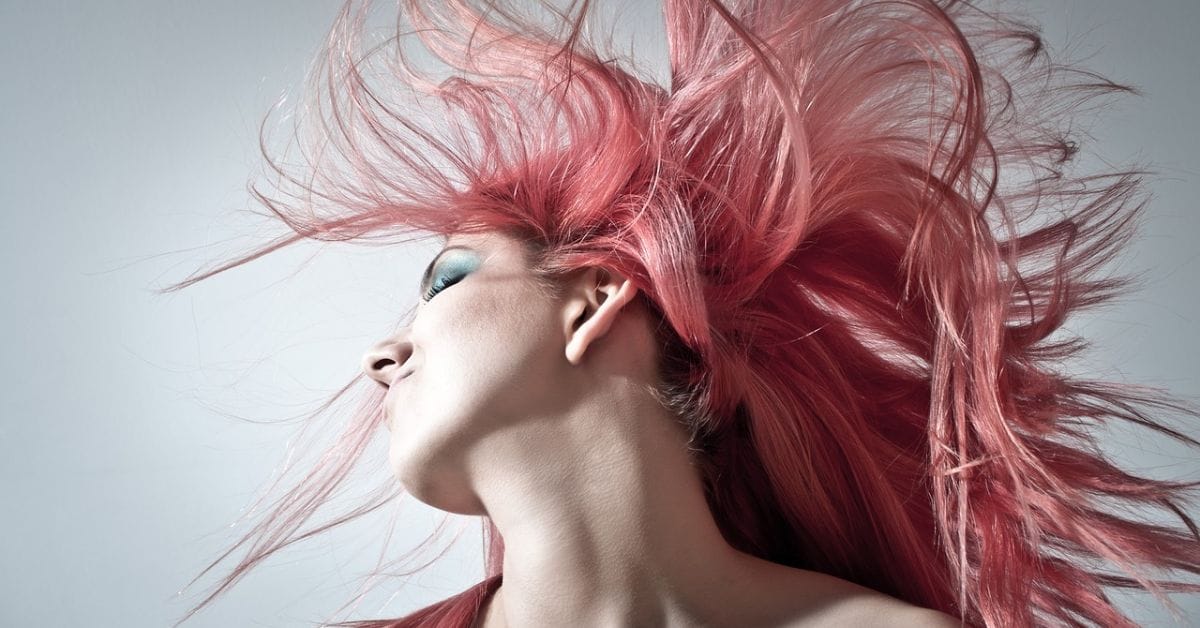 A woman with striking pink hair and a captivating blue eye, embodying the essence of iconic old money styles