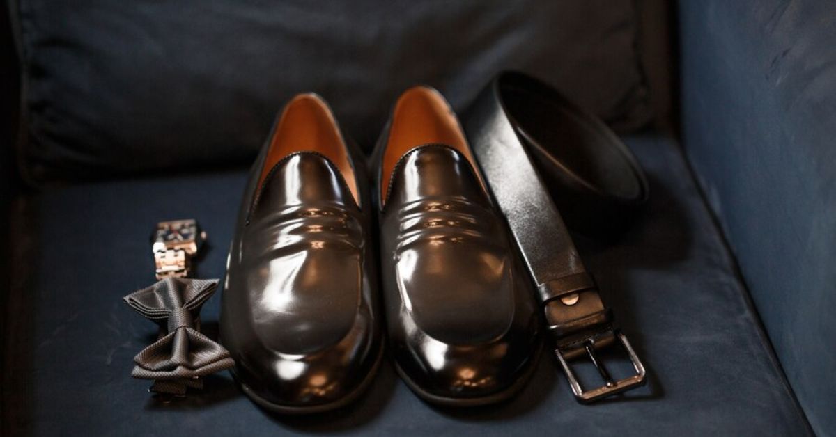 A pair of elegant black shoes, a matching belt, and stylish cufflinks, perfect for a sophisticated outfit.