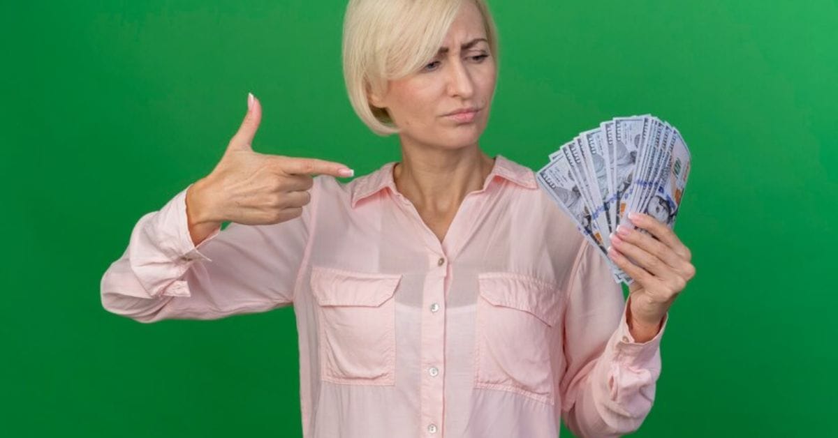 A woman holding cash while pointing at the camera, embodying a confident old money style