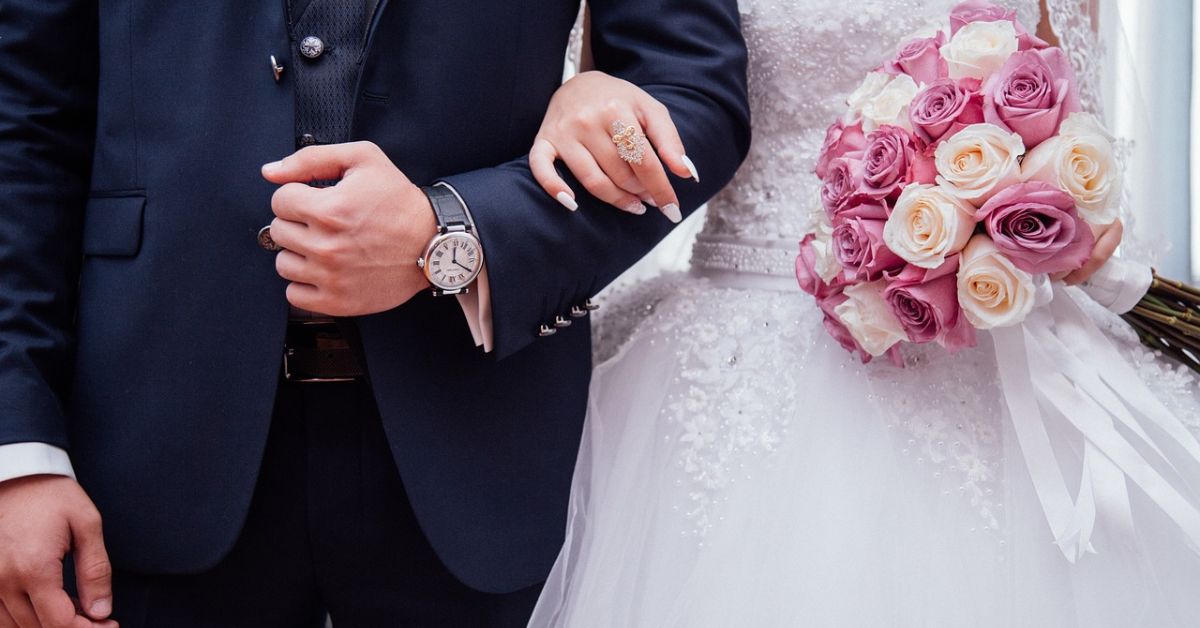  A couple in elegant wedding attire, holding hands, embodying the timeless charm of an old money wedding style.