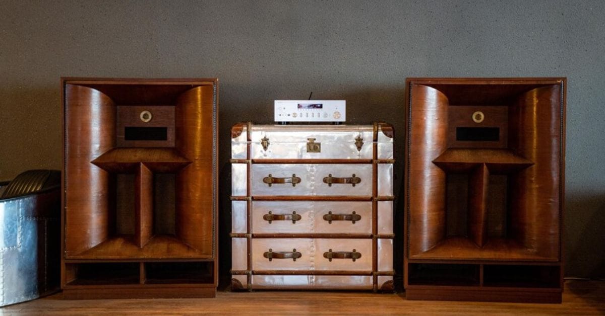 A wooden cabinet featuring speakers and a clock, embodying a classic old money aesthetic.