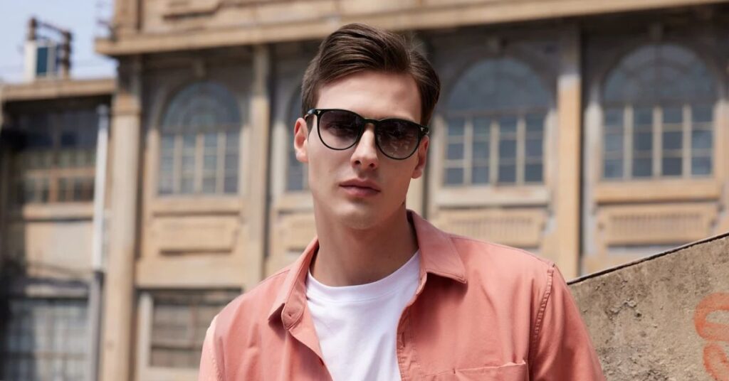 A man in a pink shirt and sunglasses embodies Old Money style, exuding elegance and sophistication.