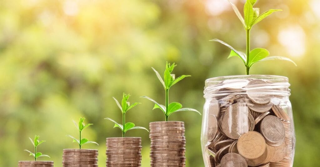  A jar filled with growing money and coins against a green background, symbolizing an old money attitude and financial growth.