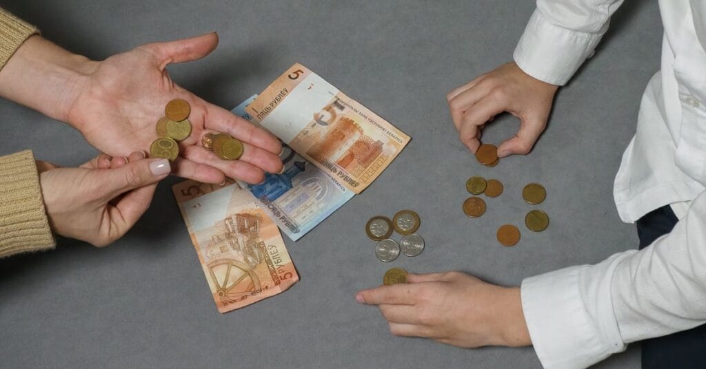 Two hands grasping cash and coins, symbolizing the essence of an Old Money Lifestyle.
