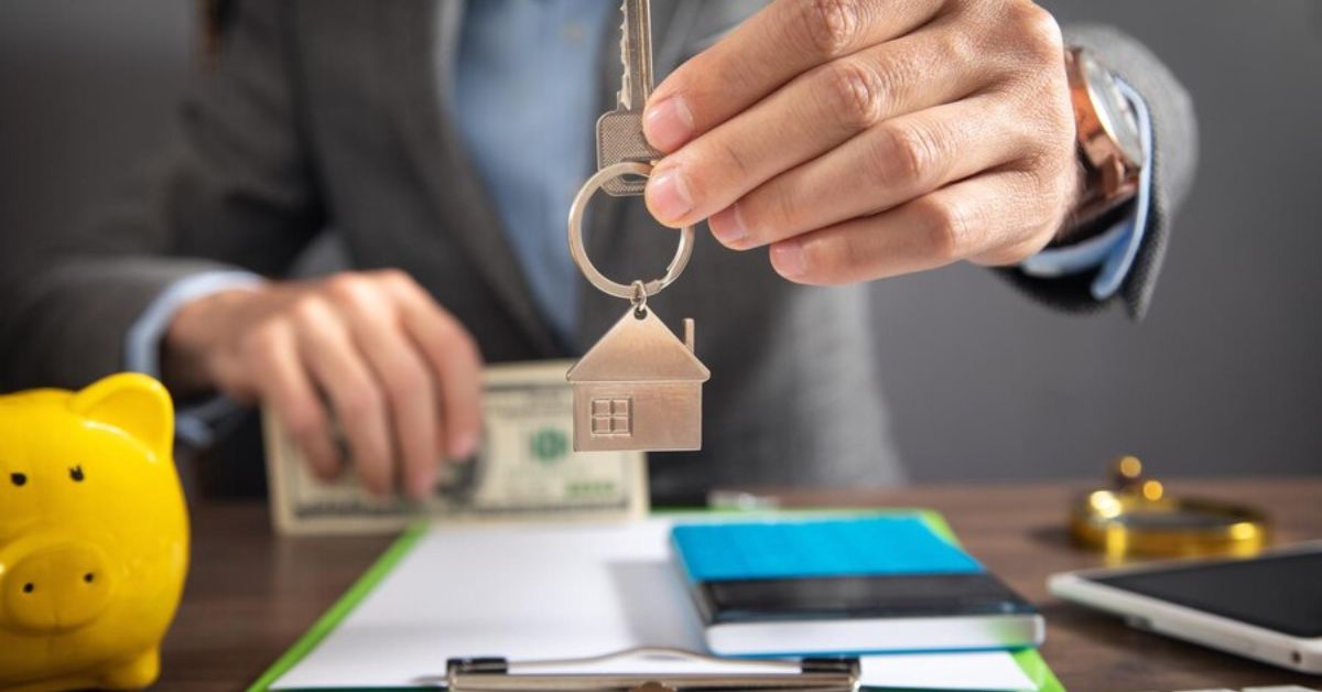 A man holds a house key and cash, symbolizing smart money-saving tips for homebuyers.