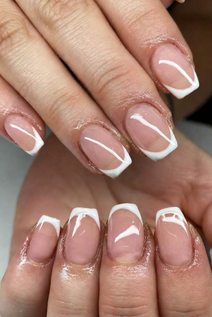 Close-up of glossy pink French manicure on elegant hands. Sheer soft pink base with delicate white tips and a high-shine finish, creating a fresh, feminine, and luxurious old money aesthetic